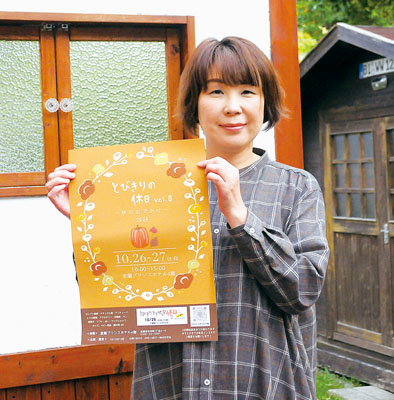 写真：ポスターを手に来場を呼びかける守谷さん