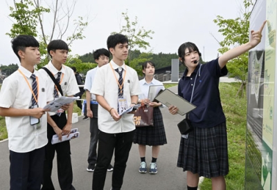 写真：宮城県南三陸町の旧防災対策庁舎周辺で、台湾の高校生に東日本大震災の伝承ガイドをする南三陸高２年の伊藤芽衣さん（右端）＝７月