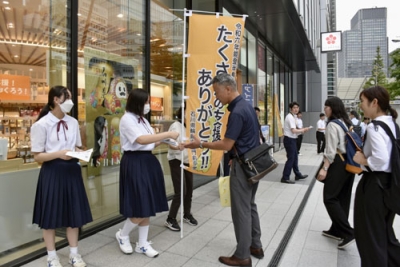 写真：カードなどを配り、能登への支援に感謝の気持ちを発信する石川県輪島市立門前中学校の生徒ら＝９月、東京・八重洲