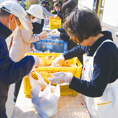 写真：袋にタマネギを詰め込む参加者