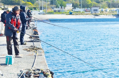 写真：黄金漁港でサケのアタリを待つ参加者