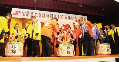 写真：祝賀会の鏡開きで１００周年を祝う出席者ら