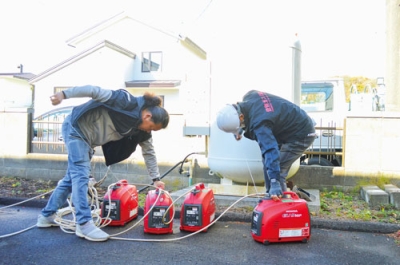 写真：発電機を起動させる職員ら