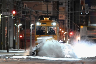 写真：今季初めて出動し、路面電車の軌道に積もった雪を掃き飛ばす「ササラ電車」＝１９日午前５時４８分、札幌市