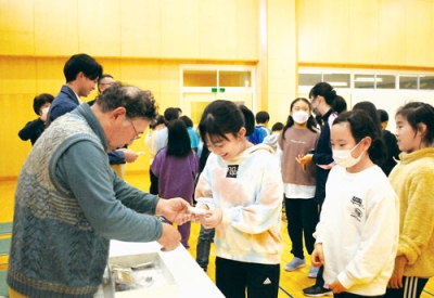 写真：室蘭・登別たたらの会からうれしそうに鉧を受け取る児童たち