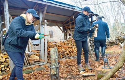 写真：まき割り体験をする参加者