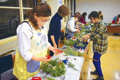 写真：リースに装飾品を付ける参加者たち