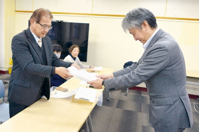 写真：市に要望書を提出した西胆振社会保障推進協議会の薩来事務局長（左）