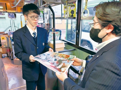 写真：ポスターを手渡す海星学院高校生徒会長の柴田さん（左）