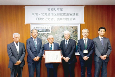 写真：表彰状を手に笑みを見せる清水さん（左から３人目）