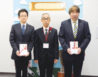 写真：善意を贈った瀬野会長（左）と栗橋会長（右）。中央は菊池会長