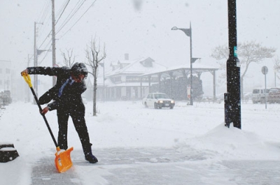 写真：降雪の中、雪かきに追われる市民＝１４日午前９時５５分ごろ、室蘭市海岸町