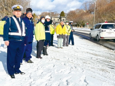 写真：死亡事故の現場で、道路の状況などを確認する関係者ら