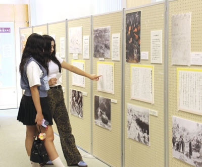 写真：沖縄県平和祈念資料館で開催中の企画展「女性が見た沖縄戦」を見学する修学旅行生＝糸満市