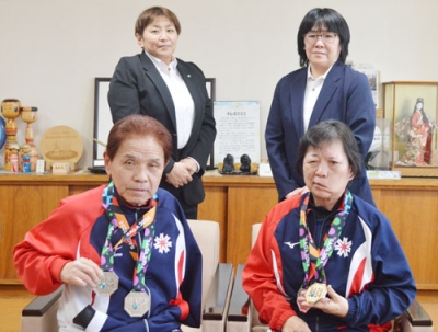 写真：メダルを手に写真に納まる髙野さん（前列左）と右田さん（前列右）