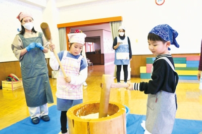 写真：かけ声に合わせて餅をつく園児たち