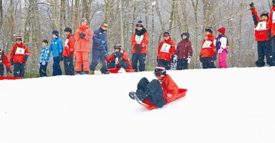 写真：そりリレーを楽しむ両市の小中学生たち