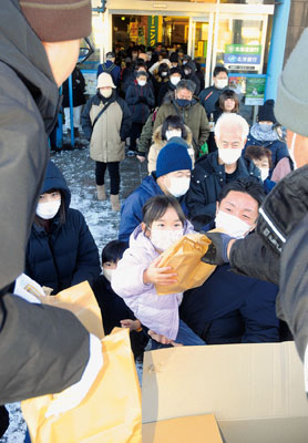 写真：商業施設「ぷらっと・てついち」前で福袋を受け取る市民ら