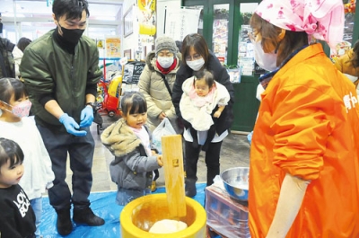 写真：ワニ広場で餅つきを楽しむ親子ら