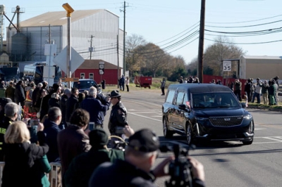 写真：４日、米南部ジョージア州で、カーター元大統領のひつぎを載せた車を沿道で見送る市民ら（ロイター＝共同）