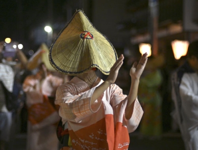 写真：「おわら風の盆」で編みがさをかぶって優雅に舞う女性＝２０２３年９月、富山市