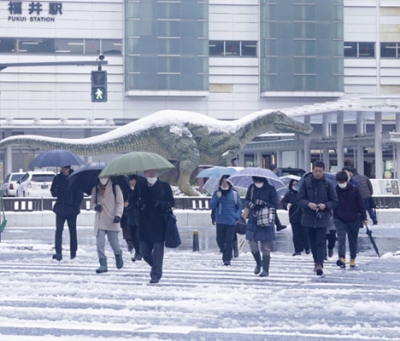 写真：積雪した福井駅前を歩く人たち＝９日午前、福井市