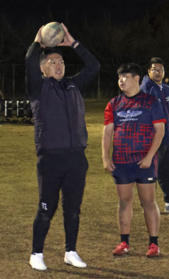 写真：能登半島地震で被災した日本航空石川高のラグビー選手をボランティアで指導する杉本博昭さん（左）＝２０２４年１２月、東京都青梅市