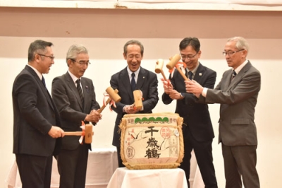 写真：鏡開きで会場を景気づける鈴木会長（中央）ら