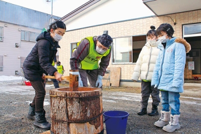 写真：一生懸命きねを振り下ろし、餅つきを楽しむ子どもたち