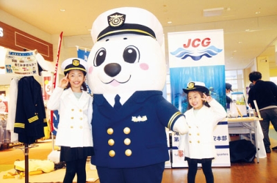 写真：海保の制服を着て記念撮影する子どもたち