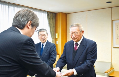 写真：新一年生用の防犯ブザーの目録を堀井市長に手渡す岩﨑会長（右）