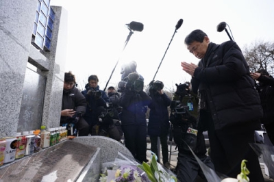 写真：スキーバス転落事故現場近くの「祈りの碑」に向かい、手を合わせる遺族会代表の田原義則さん＝１５日午前、長野県軽井沢町