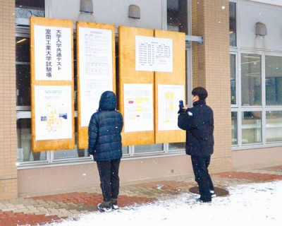 写真：雪の中、試験会場の配置を確認する受験生＝１７日午後１時１０分ごろ、室工大