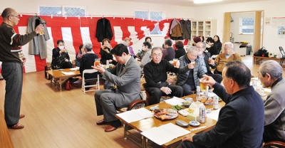 写真：新年を祝って乾杯する会員ら