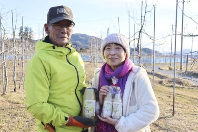 写真：佐々木朗希投手がＳＮＳで紹介したりんごジュースを手にする「煌め希りんご園」の鈴木芳弘さんと妻の桂子さん＝岩手県陸前高田市