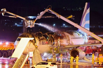 写真：韓国・釜山の金海国際空港で、火災が発生し消火活動が行われる旅客機＝２８日（聯合＝共同）