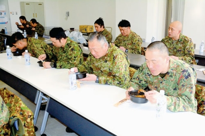 写真：ホッキカレーを食べる支援隊の隊員