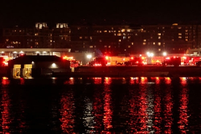 写真：２９日、旅客機の衝突事故が起きた、レーガン・ナショナル空港近くのポトマック川周辺に集まる緊急車両＝ワシントン近郊（ロイター＝共同）