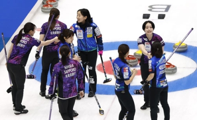 写真：女子１次リーグの初戦を終え、握手を交わすロコ・ソラーレと北海道銀行の選手たち＝横浜ＢＵＮＴＡＩ