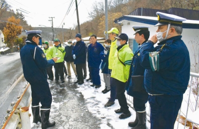 写真：本輪西町の死亡事故現場で対策について話し合う関係者