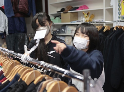 写真：古着店「ｎａｋｙａ」の店内で笑顔の古畑紫さん（右）＝１月、石川県輪島市