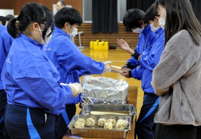 写真：東京都荒川区の区立第五中学校で、アルファ米でおにぎりを握る防災部の生徒たち＝２０２４年１２月