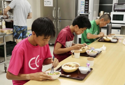 写真：佐賀県鳥栖市のアスリート寮で夕食を取る高校生＝２０２４年９月