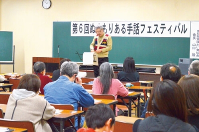 写真：手話フェスティバルで講演をする山田会長