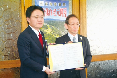 写真：協定書に押印した大塩町長（左）と松山支配人