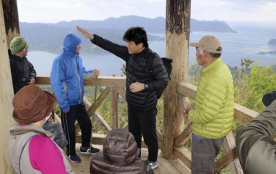 写真：鹿児島県宇検村の観光名所を巡るバスツアーで、海が一望できる展望台を訪れた参加者ら＝２月