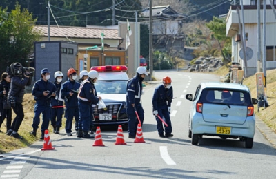 写真：大規模山林火災の避難指示が全面解除となり、道路規制を解く警察官＝１０日午前１０時５分、岩手県大船渡市三陸町越喜来