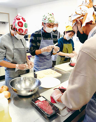 写真：料理作りを楽しむ外国人たち（提供写真）