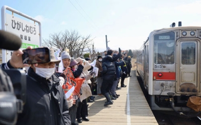 写真：ＪＲ東根室駅が営業最終日を迎え、発車する列車に手を振る人たち＝１４日午前、根室市