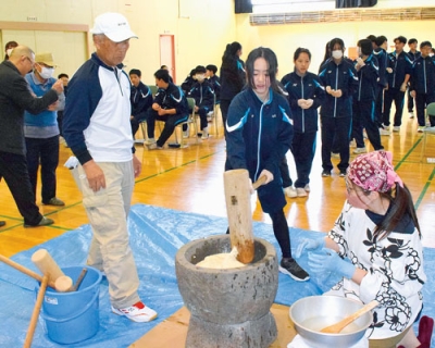 写真：町会会員が見守る中、元気よくきねを振り下ろす生徒